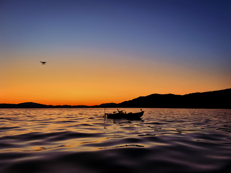 drone and boat at sunset