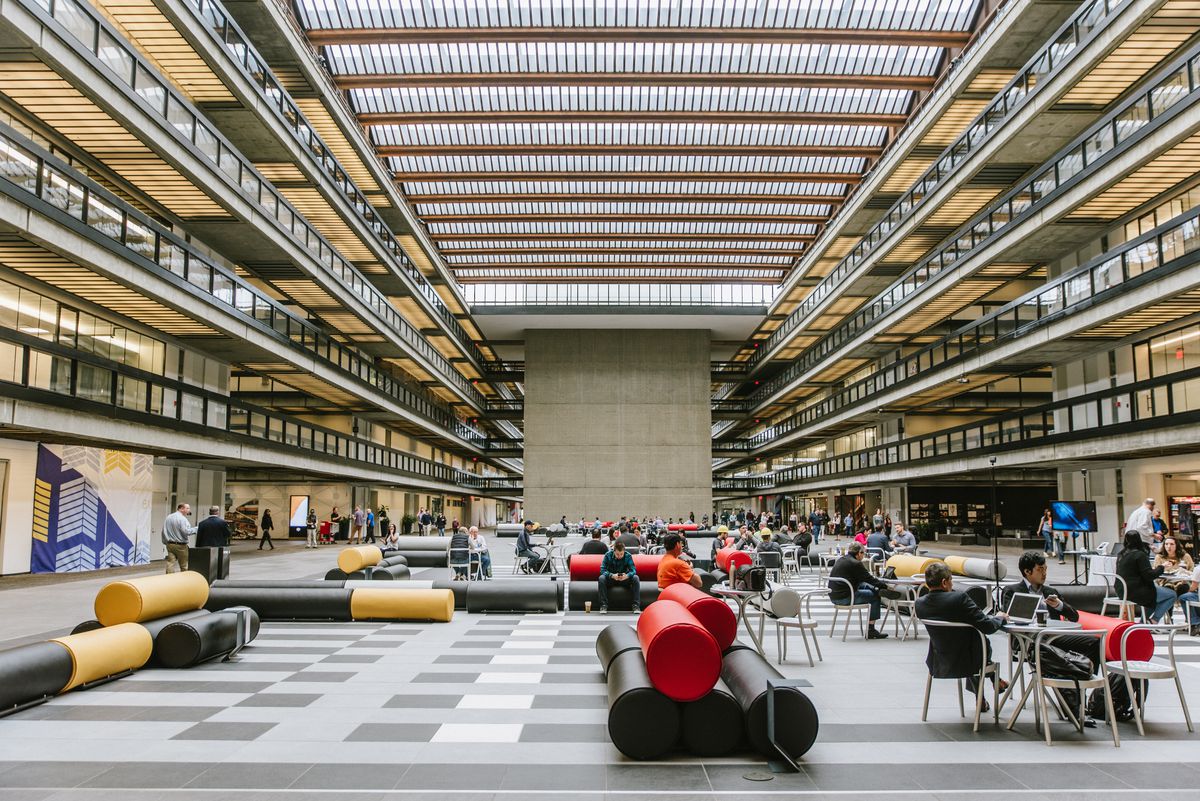 People work at tables in a mixed-use building that formerly housed a research and development&nbsp;facility for Bell Labs.