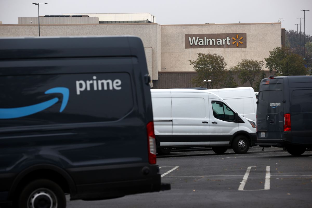 Amazon vans in front of a Walmart store.