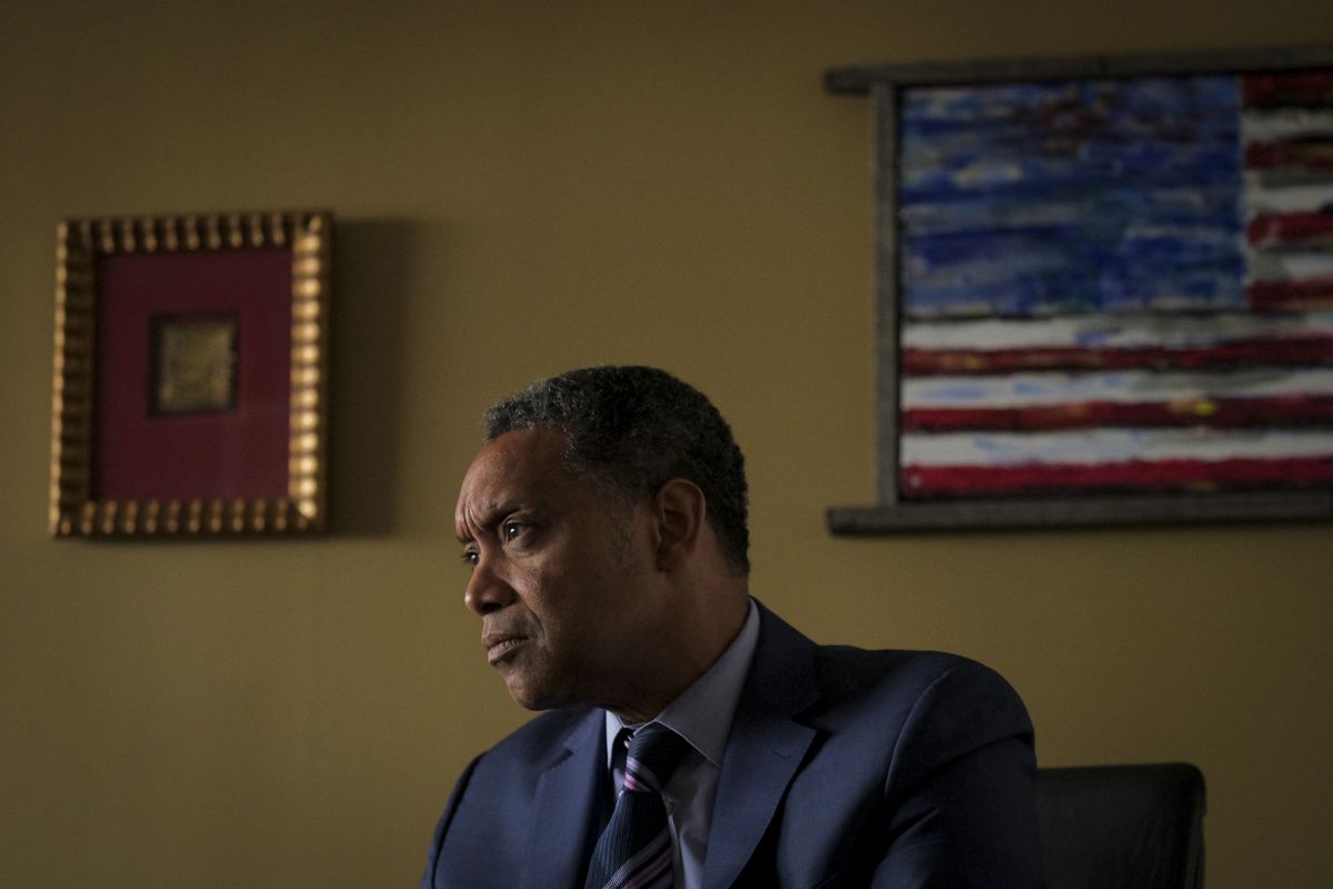 Attorney General Karl Racine sitting at his desk.