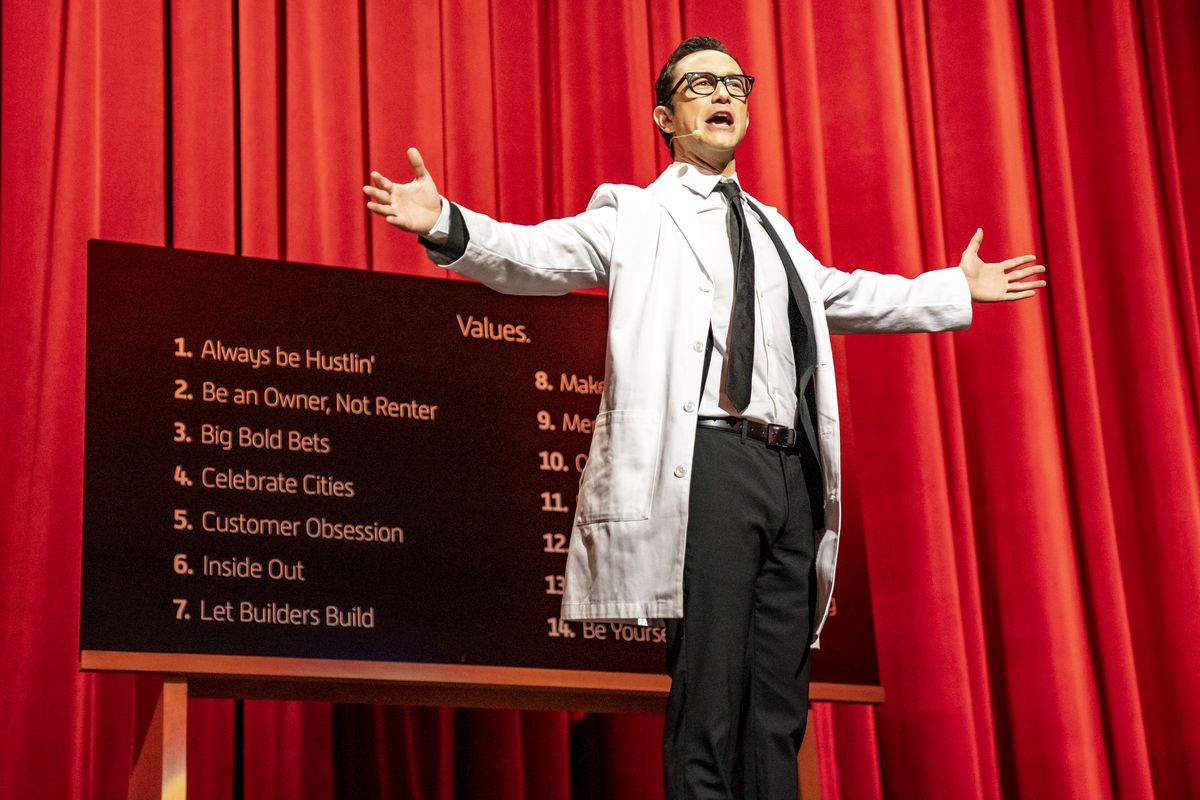 Travis Kalanick, played by Joseph Gordon-Levitt, stands onstage in front of a list of Uber’s values.