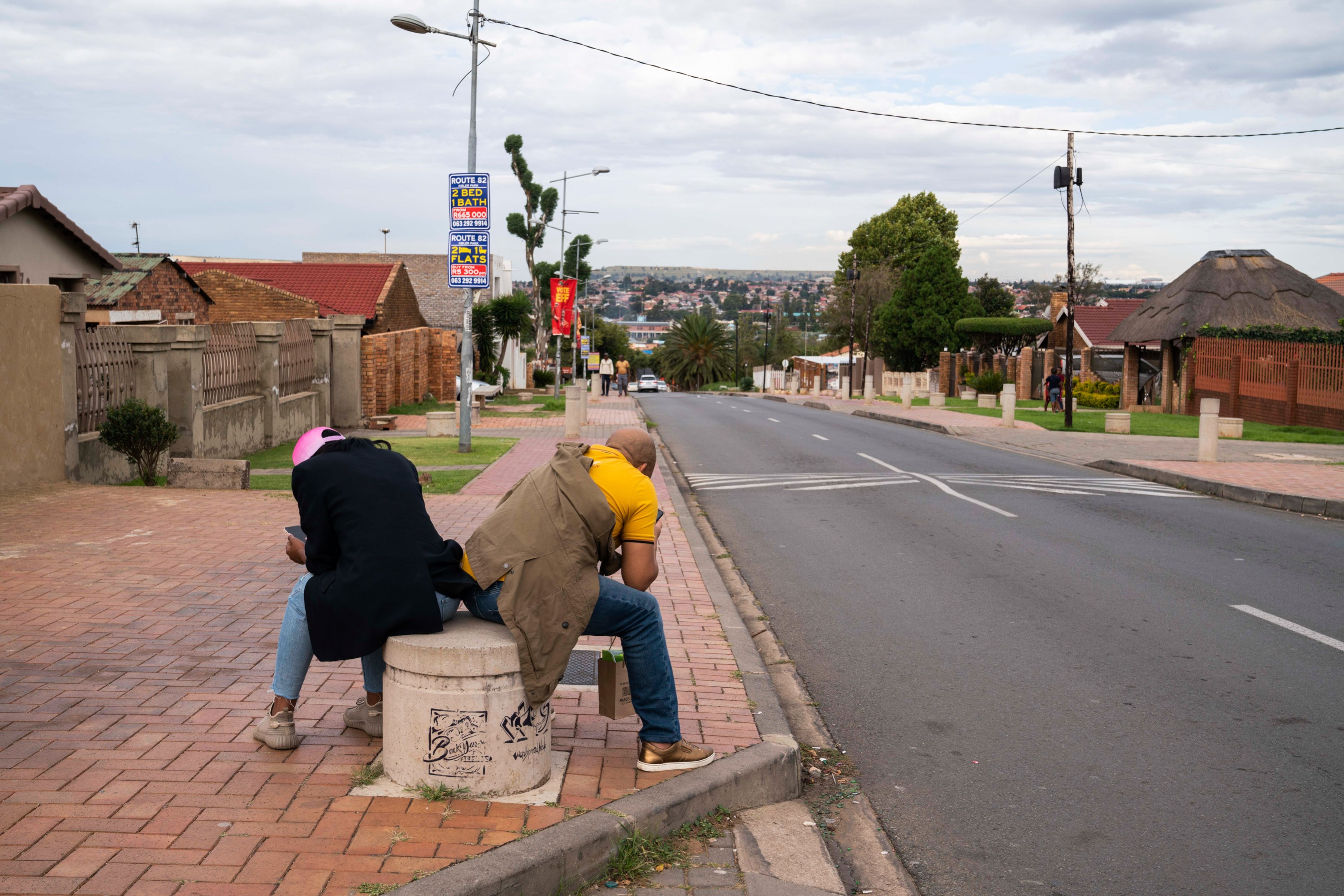 2 people on their phones on Vilakazi street.