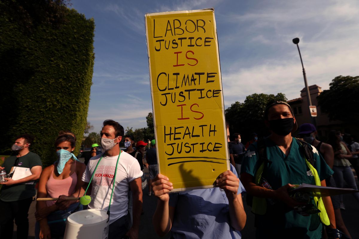 A protester holds a sign that reads, “Labor justice is climate justice is health justice.”