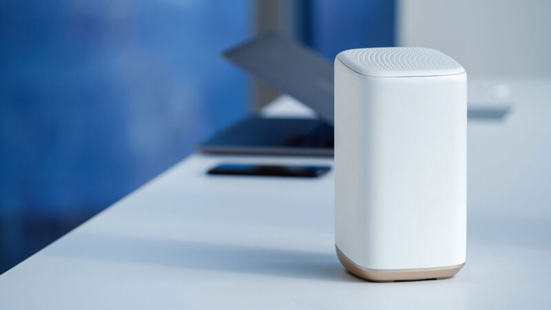 A Comcast modem/router gateway device sits on a table near a laptop.