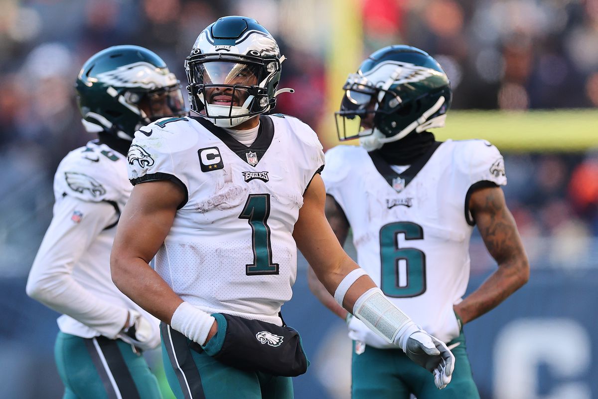 Jalen Hurts #1 of the Philadelphia Eagles talks with Quez Watkins #16 and DeVonta Smith #6 against the Chicago Bears at Soldier Field on December 18, 2022 in Chicago, Illinois