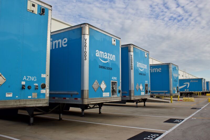 Several Amazon trailers lined up outside a shipping center.