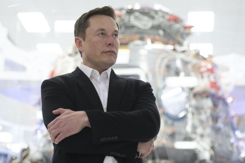 SpaceX CEO Elon Musk standing with his arms crossed.