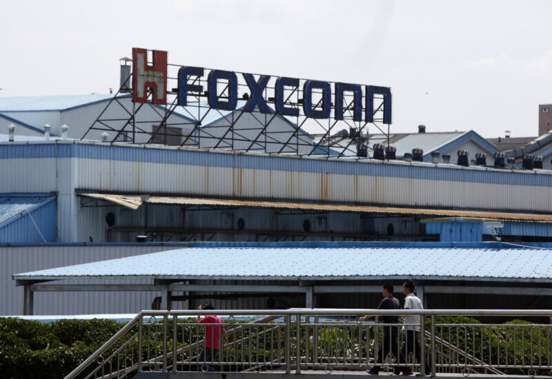 Workers walk outside Hon Hai Group's Foxconn plant in Shenzhen, China, in 2010.