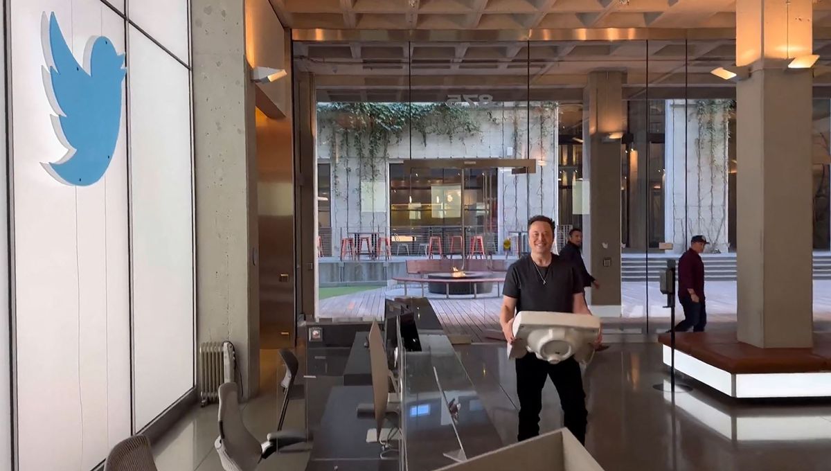 Elon Musk in Twitter headquarters carrying a sink.